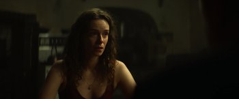 Movie still from “The Pope's Exorcist” (2023), directed by Julius Avery – A woman with long brown curly hair looking at the camera; Close Up shot, Over the shoulder angle