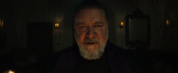 Movie still from “The Pope's Exorcist” (2023), directed by Julius Avery – An older man with a beard is looking at the camera; Close Up shot, Low angle