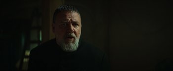 Movie still from “The Pope's Exorcist” (2023), directed by Julius Avery – An older man with a beard is looking at the camera; Close Up shot, Low angle