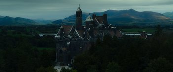 Movie still from “The Pope's Exorcist” (2023), directed by Julius Avery – An old building with a clock on the top of it; Extreme Wide shot, Low angle