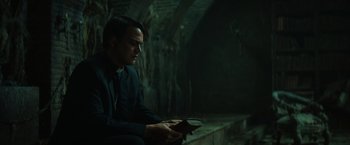 Movie still from “The Pope's Exorcist” (2023), directed by Julius Avery – A man in a black suit is holding a book; Medium shot, High angle