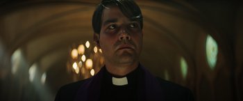 Movie still from “The Pope's Exorcist” (2023), directed by Julius Avery – A man in a priest's outfit looking into the distance; Close Up shot, Low angle
