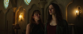 Movie still from “The Pope's Exorcist” (2023), directed by Julius Avery – Two women standing next to each other in front of a window; Close Up shot, Low angle