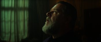 Movie still from “The Pope's Exorcist” (2023), directed by Julius Avery – A person with a beard looking up; Close Up shot, Low angle