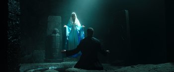 Movie still from “The Pope's Exorcist” (2023), directed by Julius Avery – A man standing in front of a statue of a woman; Wide shot, Low angle