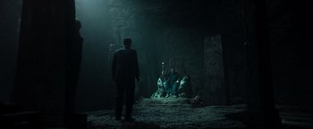 Movie still from “The Pope's Exorcist” (2023), directed by Julius Avery – A man and a woman sitting on a chair in a dark room; Wide shot, High angle