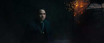 Movie still from “The Pope's Exorcist” (2023), directed by Julius Avery – A man wearing a black suit and a black tie; Medium shot, Low angle