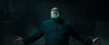 Movie still from “The Pope's Exorcist” (2023), directed by Julius Avery – An old man with a beard is standing in the dark; Medium shot, Low angle