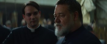 Movie still from “The Pope's Exorcist” (2023), directed by Julius Avery – A man with a long beard and a clergyman; Close Up shot, Over the shoulder angle