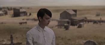 Movie still from “The Power of the Dog” (2021), directed by Jane Campion – A man in a white shirt standing in the middle of a field; Medium shot, Over the shoulder angle