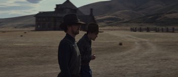 Movie still from “The Power of the Dog” (2021), directed by Jane Campion – A couple of men walking across a dry grass field; Wide shot, Low angle