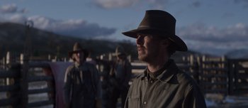Movie still from “The Power of the Dog” (2021), directed by Jane Campion – A group of people standing next to each other wearing hats; Medium shot, Over the shoulder angle