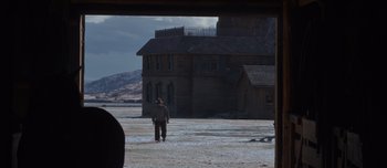 Movie still from “The Power of the Dog” (2021), directed by Jane Campion – A man standing in front of an old building; Extreme Wide shot, Over the shoulder angle
