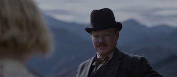 Movie still from “The Power of the Dog” (2021), directed by Jane Campion – A man in a suit and a bow tie wearing a top hat; Close Up shot, Low angle