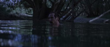 Movie still from “The Power of the Dog” (2021), directed by Jane Campion – A man swimming in a body of water at night; Wide shot, High angle