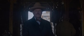 Movie still from “The Power of the Dog” (2021), directed by Jane Campion – A man with a mustache wearing a suit and a hat; Close Up shot, Low angle