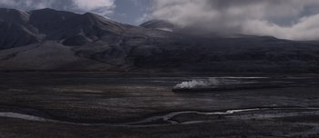 Movie still from “The Power of the Dog” (2021), directed by Jane Campion – A train traveling through a valley near a mountain range; Extreme Wide shot, High angle