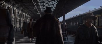 Movie still from “The Power of the Dog” (2021), directed by Jane Campion – A man wearing a fur coat and a hat walking down a train platform; Wide shot, Over the shoulder angle
