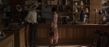 Movie still from “The Power of the Dog” (2021), directed by Jane Campion – A man and a woman standing in front of a store; Wide shot, Over the shoulder angle