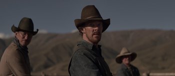 Movie still from “The Power of the Dog” (2021), directed by Jane Campion – A man wearing a cowboy hat in the middle of a field; Medium shot, Over the shoulder angle