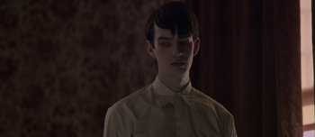 Movie still from “The Power of the Dog” (2021), directed by Jane Campion – A young man in a white dress shirt and black tie; Close Up shot, Over the shoulder angle