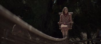 Movie still from “The Power of the Dog” (2021), directed by Jane Campion – A woman sitting in a chair on top of a boat; Wide shot, High angle
