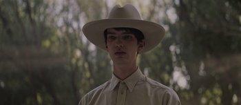 Movie still from “The Power of the Dog” (2021), directed by Jane Campion – A young man wearing a white cowboy hat; Close Up shot, Low angle