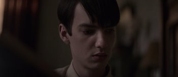 Movie still from “The Power of the Dog” (2021), directed by Jane Campion – A young man with short black hair is looking at the camera; Close Up shot, Over the shoulder angle