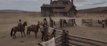 Movie still from “The Power of the Dog” (2021), directed by Jane Campion – A group of people standing around a fence; Extreme Wide shot, Low angle