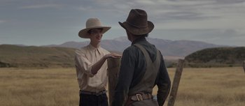 Movie still from “The Power of the Dog” (2021), directed by Jane Campion – Two men in cowboy hats standing next to each other; Medium shot, Over the shoulder angle