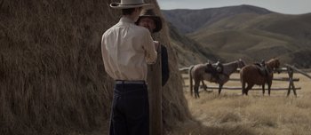 Movie still from “The Power of the Dog” (2021), directed by Jane Campion – Two men standing next to each other in a field; Medium shot, Over the shoulder angle