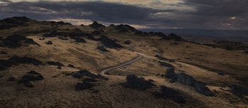 Movie still from “The Power of the Dog” (2021), directed by Jane Campion – An aerial view of a winding road in the middle of a valley; Extreme Wide shot, High angle