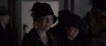Movie still from “The Power of the Dog” (2021), directed by Jane Campion – A woman wearing a black hat in a dark room; Close Up shot, Over the shoulder angle