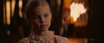 Movie still from “The Prestige” (2006), directed by Christopher Nolan – A little girl in a white dress looking at the camera; Close Up shot, Over the shoulder angle