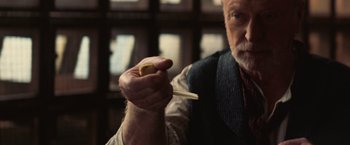 Movie still from “The Prestige” (2006), directed by Christopher Nolan – An older man holding a piece of paper in his hand; Close Up shot, High angle