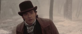 Movie still from “The Prestige” (2006), directed by Christopher Nolan – A person wearing a hat and a jacket; Close Up shot, Over the shoulder angle