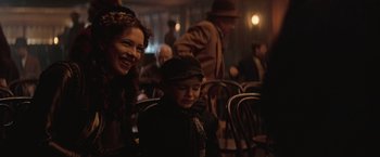 Movie still from “The Prestige” (2006), directed by Christopher Nolan – A woman and a boy sitting next to each other in a room; Medium shot, Over the shoulder angle