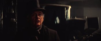 Movie still from “The Prestige” (2006), directed by Christopher Nolan – An older man wearing a top hat and a coat; Close Up shot, Over the shoulder angle