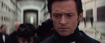 Movie still from “The Prestige” (2006), directed by Christopher Nolan – A person wearing a suit and tie; Close Up shot, Low angle