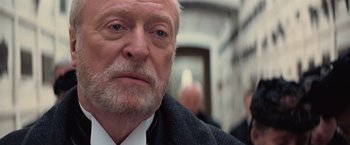 Movie still from “The Prestige” (2006), directed by Christopher Nolan – An old man with a beard and a white mustache; Close Up shot, Over the shoulder angle