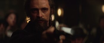 Movie still from “The Prestige” (2006), directed by Christopher Nolan – A man with a long beard is holding a gun; Close Up shot, Low angle