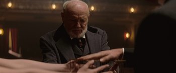 Movie still from “The Prestige” (2006), directed by Christopher Nolan – An older man in a suit and tie playing a game of cribbage; Close Up shot, Over the shoulder angle