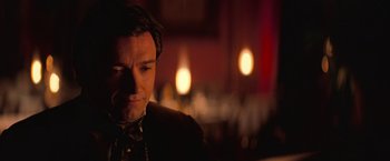 Movie still from “The Prestige” (2006), directed by Christopher Nolan – A person wearing a suit and tie; Close Up shot, Over the shoulder angle