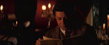 Movie still from “The Prestige” (2006), directed by Christopher Nolan – A man in a suit and tie reading a newspaper; Close Up shot, Over the shoulder angle