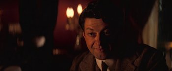 Movie still from “The Prestige” (2006), directed by Christopher Nolan – A person wearing a suit and tie; Close Up shot, Over the shoulder angle