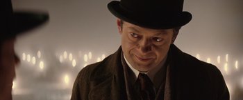 Movie still from “The Prestige” (2006), directed by Christopher Nolan – A person wearing a hat; Close Up shot, Over the shoulder angle