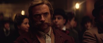 Movie still from “The Prestige” (2006), directed by Christopher Nolan – A person wearing a suit and tie; Close Up shot, Low angle