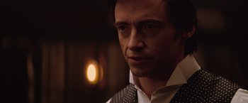 Movie still from “The Prestige” (2006), directed by Christopher Nolan – A person wearing a suit and tie; Close Up shot, Over the shoulder angle