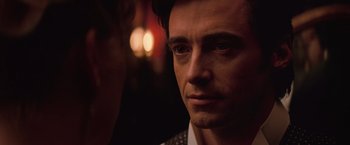 Movie still from “The Prestige” (2006), directed by Christopher Nolan – A person looking at the camera; Close Up shot, Over the shoulder angle