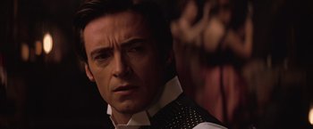 Movie still from “The Prestige” (2006), directed by Christopher Nolan – A man in a vest and tie looking at the camera; Close Up shot, Over the shoulder angle